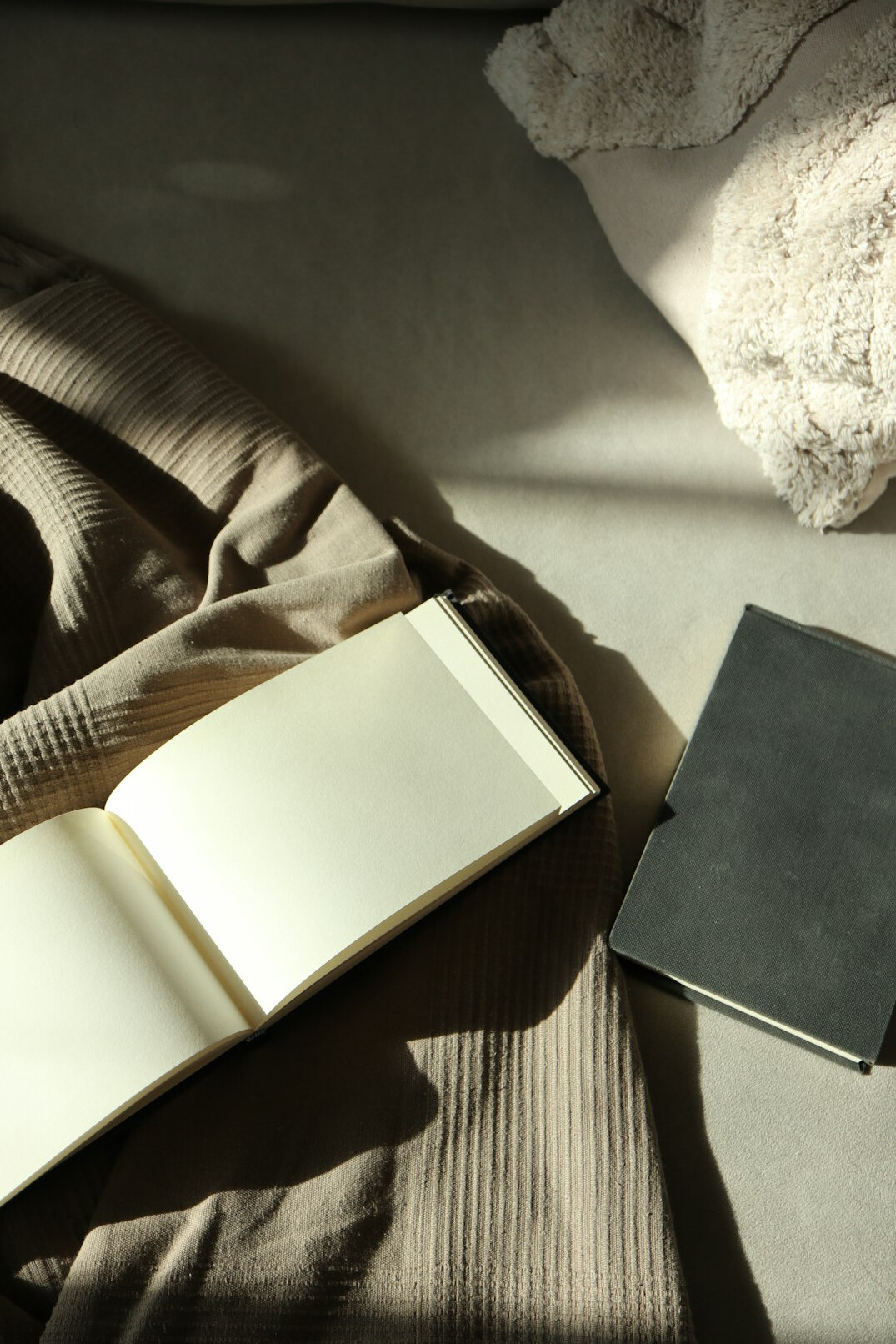 Hand writing notes in a notebook next to a laptop