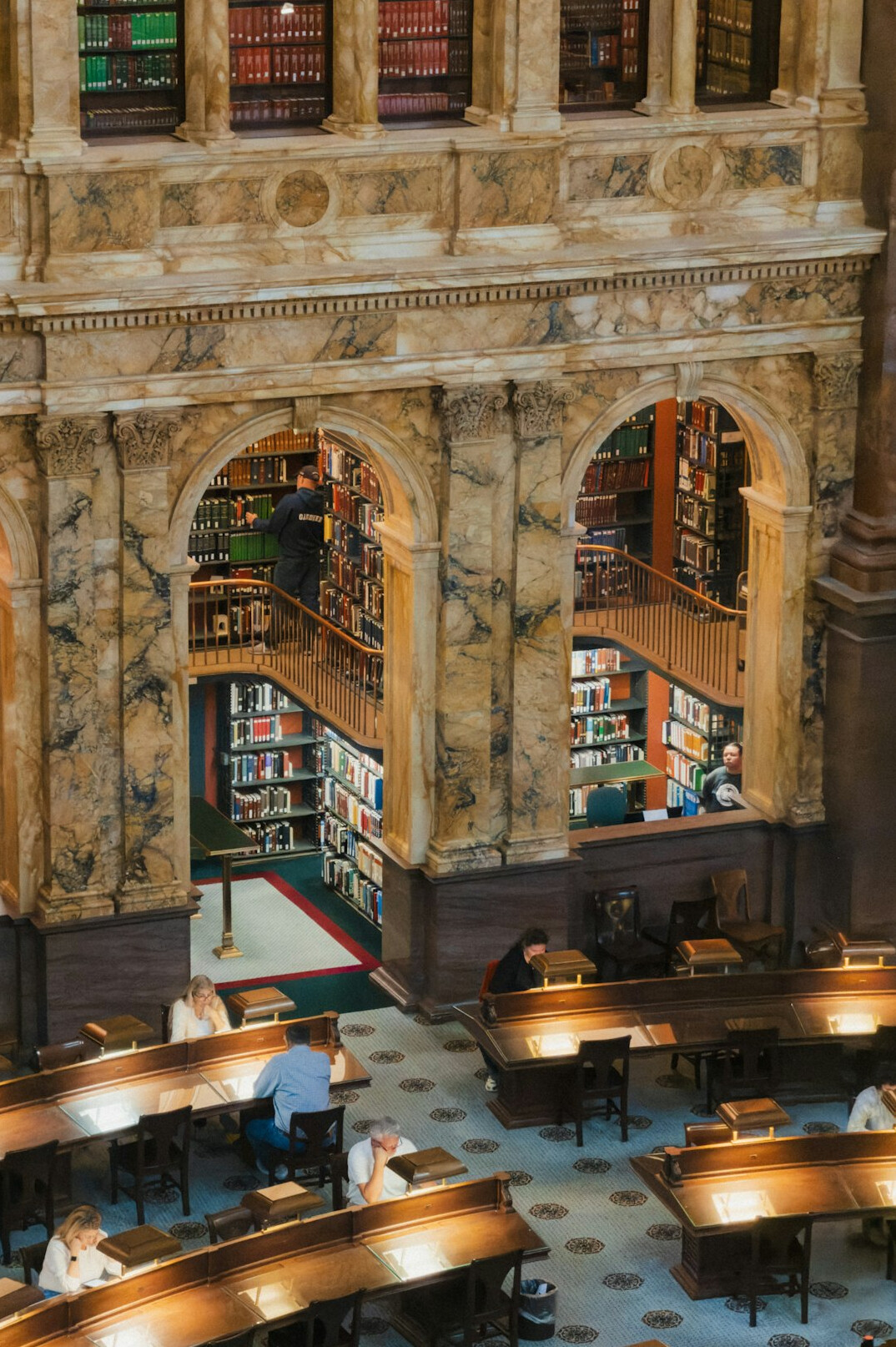 Grand library interior with tall bookshelves and reading tables