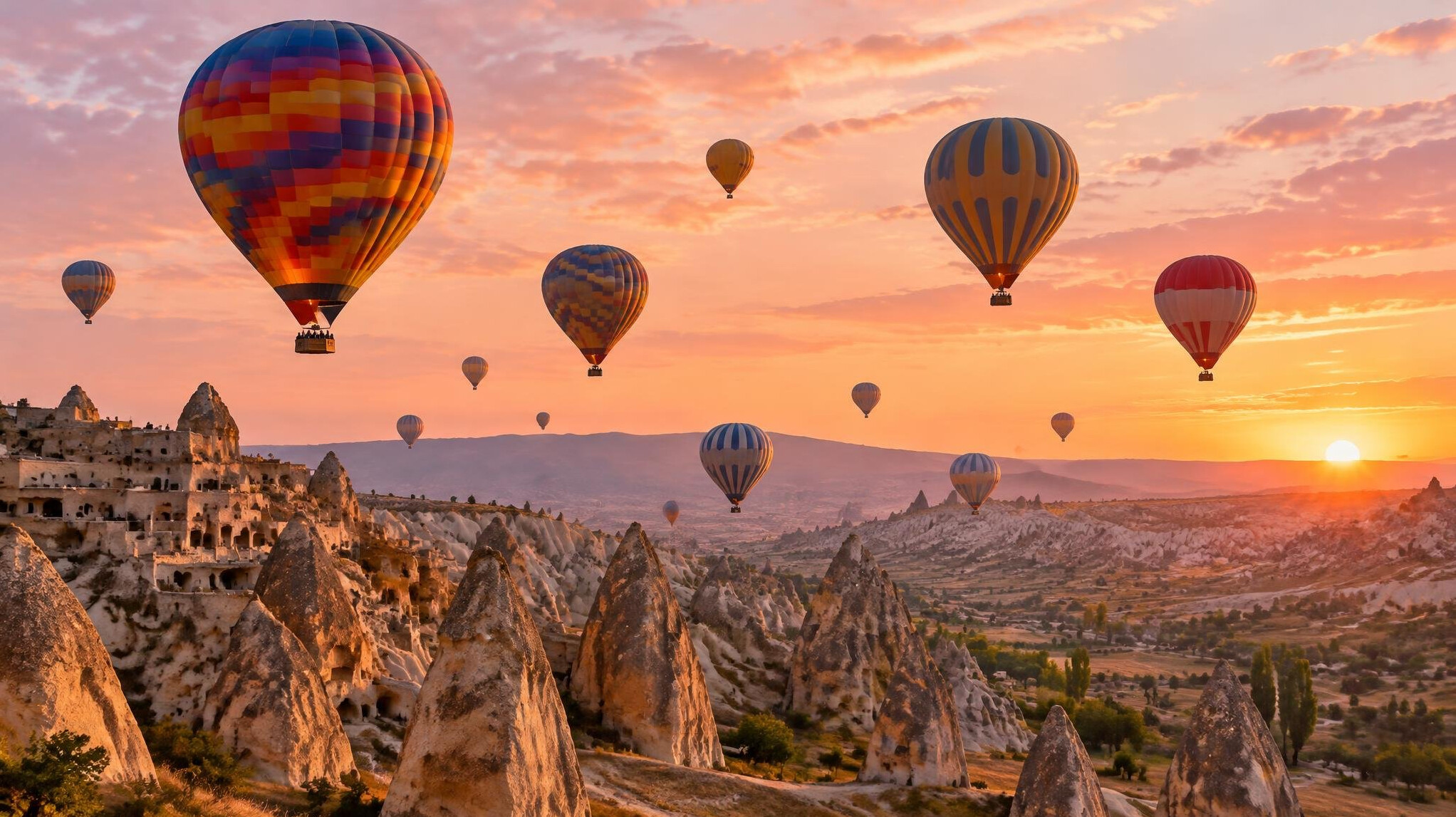 Hot air balloons over rocky landscape at sunrise