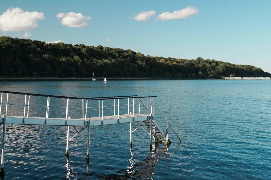 Seaside promenade with calm blue water and a clear sky